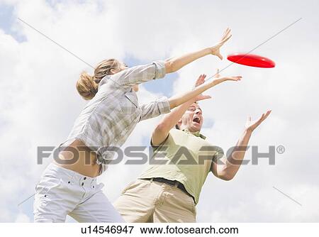 Stock Photo - Couple playing with frisbee. Fotosearch