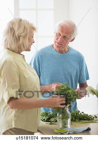 Picture - Couple preparing food in kitchen. Fotosearch