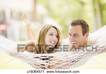 Stock Image - Couple relaxing in hammock. Fotosearch