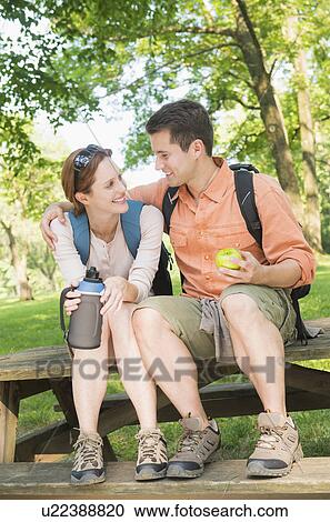 Stock Image - Couple resting during hiking in forest. Fotosearch