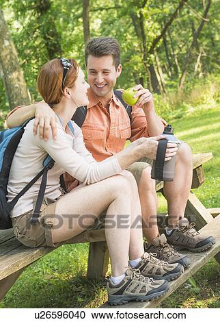Stock Image - Couple resting during hiking in forest. Fotosearch