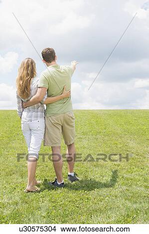 Couple standing on grass and embracing View Large Photo Image Picture - Couple standing on grass and embracing. Fotosearch