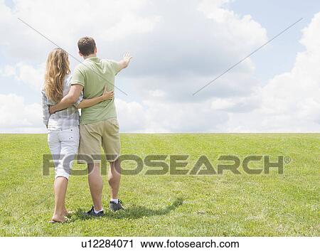 Couple standing on grass and embracing View Large Photo Image Stock Image - Couple standing on grass and embracing. Fotosearch