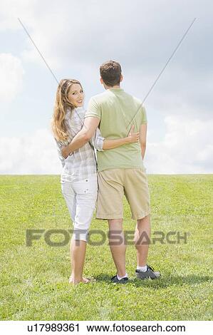 Couple standing on grass and embracing View Large Photo Image Stock Image - Couple standing on grass and embracing. Fotosearch