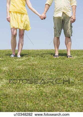 Couple standing on meadow View Large Photo Image Stock Image - Couple standing on meadow. Fotosearch
