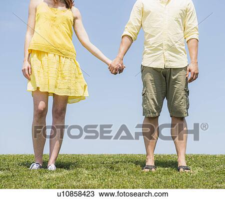 Couple standing on meadow View Large Photo Image Stock Image - Couple standing on meadow. Fotosearch