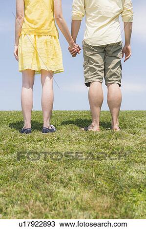Couple standing on meadow View Large Photo Image Stock Image - Couple standing on meadow. Fotosearch