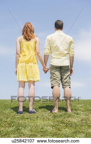 Stock Photo - Couple standing on meadow. Fotosearch
