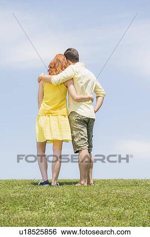 Stock Photograph - Couple standing on meadow. Fotosearch
