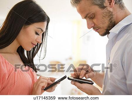 Couple using cell phone View Large Photo Image Stock Photo - Couple using cell phone. Fotosearch
