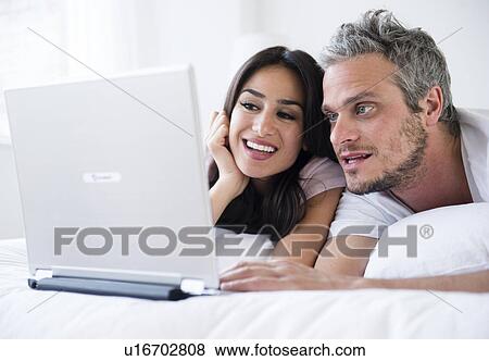 Couple using laptop View Large Photo Image Stock Photo - Couple using laptop. Fotosearch
