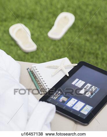 Digital tablet and notebook on lounger View Large Photo Image Stock Photo - Digital tablet and notebook on lounger. Fotosearch