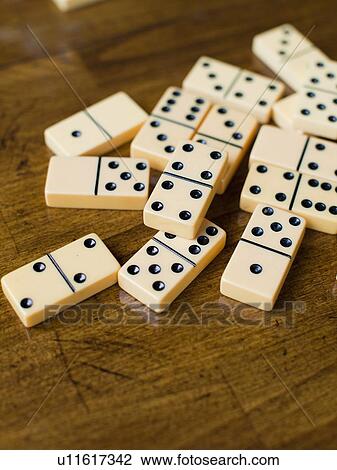 Stock Image - Domino tiles on wooden surface, studio shot. Fotosearch