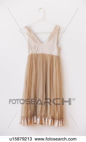 Dress with frill on hanger against white wall View Large Photo Image Stock Image - Dress with frill on hanger against white wall. Fotosearch