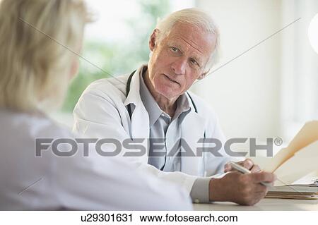 Stock Image - Female and male doctors discussing. Fotosearch