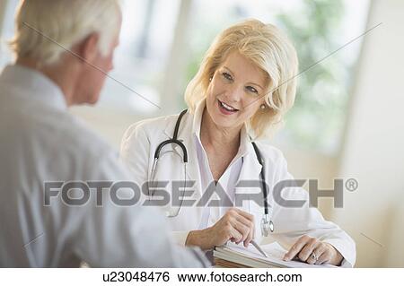 Female and male doctors talking View Large Photo Image Stock Photograph - Female and male doctors talking. Fotosearch