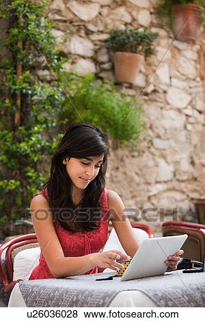 France, Cassis, Young woman using digital tablet in cafe View Large Photo Image Stock Photo - France, Cassis, Young woman using digital tablet in cafe. Fotosearch