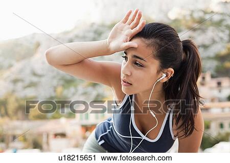 Stock Image - France, Marseille, Young woman in tracksuit and with headphones. Fotosearch