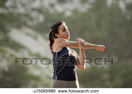 Stock Photo - France, Marseille, Young woman stretching. Fotosearch