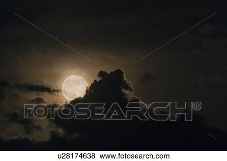 Stock Photo - Full moon emerging from clouds. Fotosearch