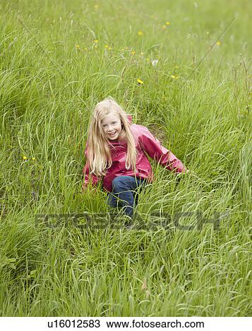 Stock Image - Girl playing among grass. Fotosearch