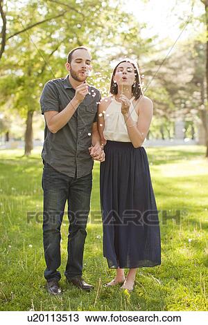 Happy young couple blowing bubbles View Large Photo Image Stock Image - Happy young couple blowing bubbles. Fotosearch
