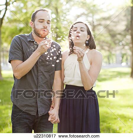 Happy young couple blowing bubbles View Large Photo Image Stock Photo - Happy young couple blowing bubbles. Fotosearch