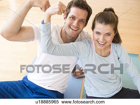 Stock Photography - Happy young couple flexing muscles . Fotosearch