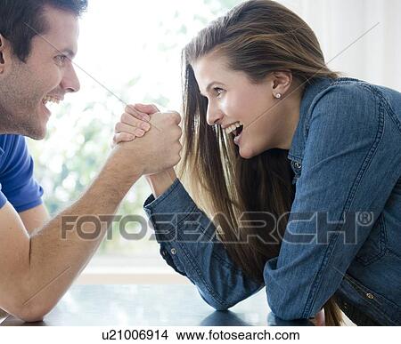 Happy young couple hand wrestling View Large Photo Image Picture - Happy young couple hand wrestling. Fotosearch