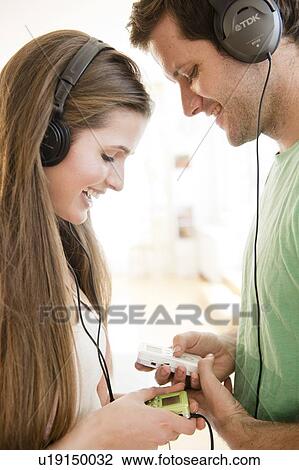 Happy young couple listening to music View Large Photo Image Stock Image - Happy young couple listening to music. Fotosearch