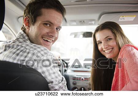 Happy young couple sitting in car View Large Photo Image Stock Image - Happy young couple sitting in car. Fotosearch