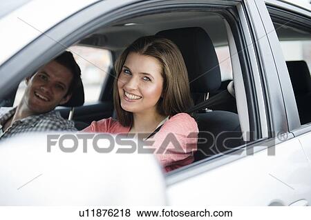 Stock Photo - Happy young couple sitting in car. Fotosearch