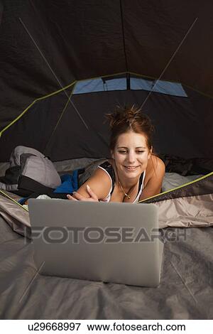 Hiker in tent using laptop View Large Photo Image Stock Photo - Hiker in tent using laptop. Fotosearch