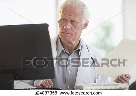 Male doctor working on computer View Large Photo Image Stock Photo - Male doctor working on computer. Fotosearch