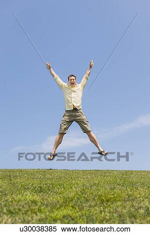 Man jumping on meadow View Large Photo Image Stock Photography - Man jumping on meadow. Fotosearch