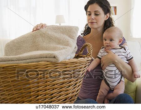 Mother and baby boy (2-5 months) doing laundry View Large Photo Image Stock Photo - Mother and baby boy (2-5 months) doing laundry. Fotosearch