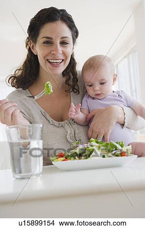 Picture - Mother and baby boy (2-5 months) eating salad. Fotosearch