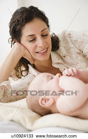 Mother and baby boy (2-5 months) plying together on bed View Large Photo Image Stock Image - Mother and baby boy (2-5 months) plying together on bed. Fotosearch