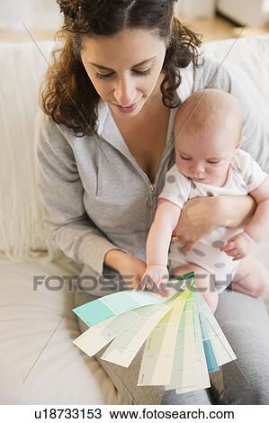 Stock Image - Mother and baby boy (2-5 months) checking colors samples. Fotosearch