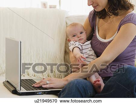 Mother with baby boy (2-5 months) using laptop View Large Photo Image Stock Image - Mother with baby boy (2-5 months) using laptop. Fotosearch