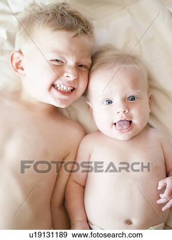 Stock Photo - Portrait of boy (2-3) with baby sister (6-11 months). Fotosearch