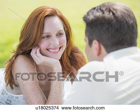 Picture - Portrait of couple lying on blanket and smiling. Fotosearch