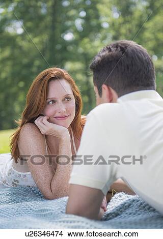 Picture - Portrait of couple lying on blanket and smiling. Fotosearch