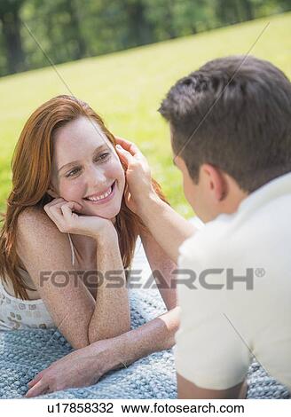 Portrait of couple lying on blanket and smiling View Large Photo Image Stock Image - Portrait of couple lying on blanket and smiling. Fotosearch