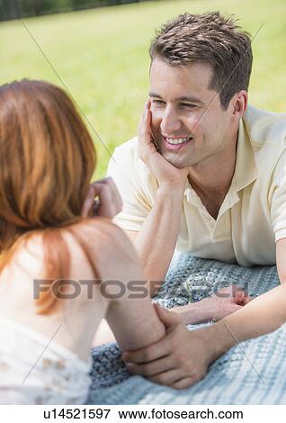 Portrait of couple lying on blanket and smiling View Large Photo Image Stock Photo - Portrait of couple lying on blanket and smiling. Fotosearch