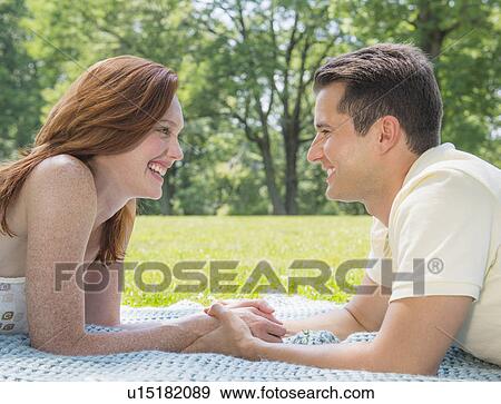 Portrait of couple lying on blanket and smiling View Large Photo Image Stock Photo - Portrait of couple lying on blanket and smiling. Fotosearch