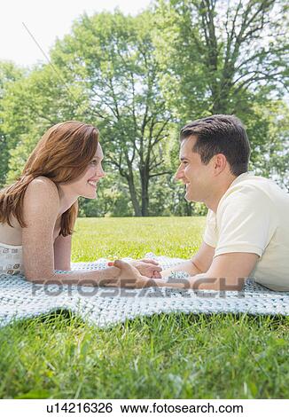 Portrait of couple lying on blanket and smiling View Large Photo Image Stock Photograph - Portrait of couple lying on blanket and smiling. Fotosearch