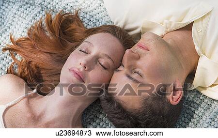 Stock Image - Portrait of couple lying on blanket. Fotosearch