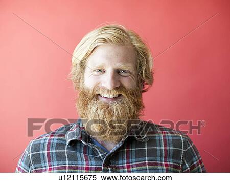 Stock Photography - Portrait of smiling man with beard, studio shot. Fotosearch