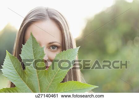 Portrait of woman holding green leaf View Large Photo Image Stock Image - Portrait of woman holding green leaf. Fotosearch